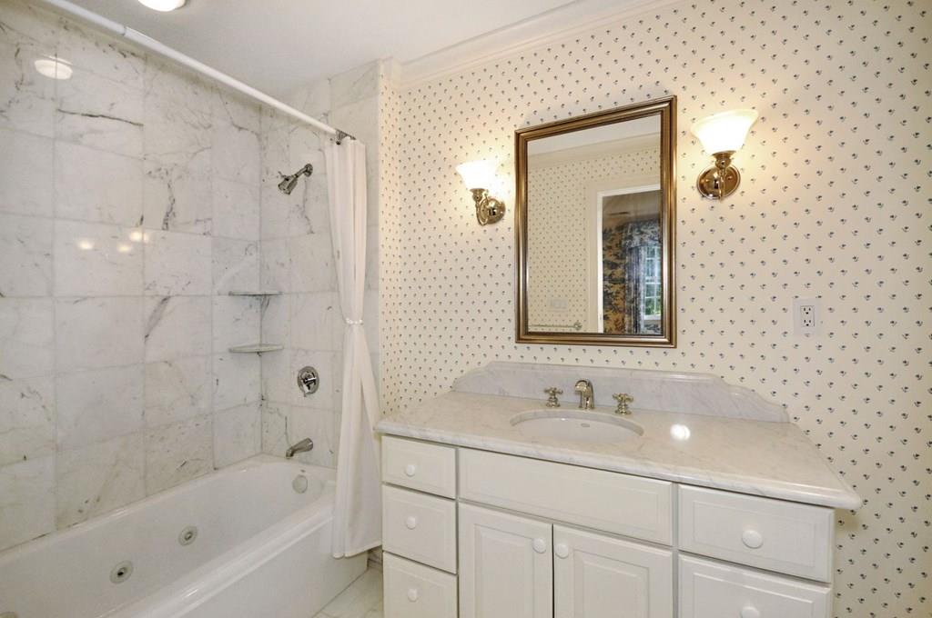 103 Revolutionary Road Concord, MA 01742 - Photo 33 of 39 a bathroom with a granite countertop sink a mirror a shower and a bathtub