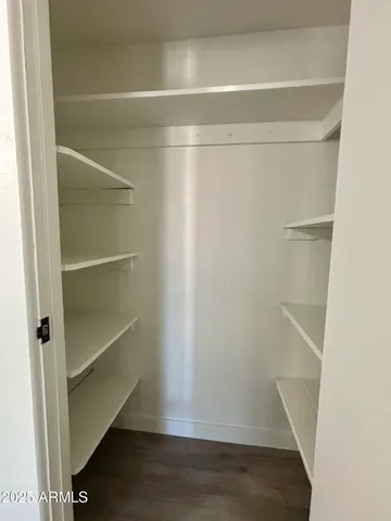 a view of walk in closet with empty racks