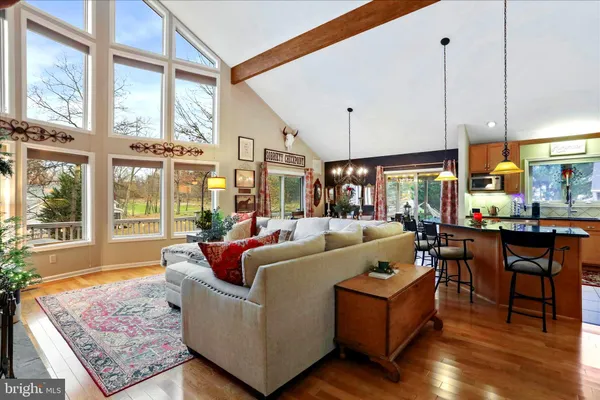 a living room with furniture large window and wooden floor