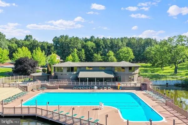 a view of a swimming pool with a patio and a yard