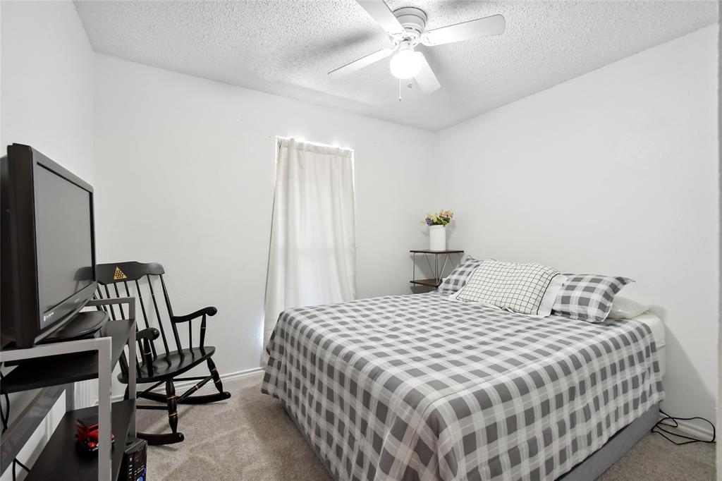 3129 Regency Carrollton, TX 75007 - Photo 18 of 29 a bedroom with a bed a flat screen tv and a chandelier