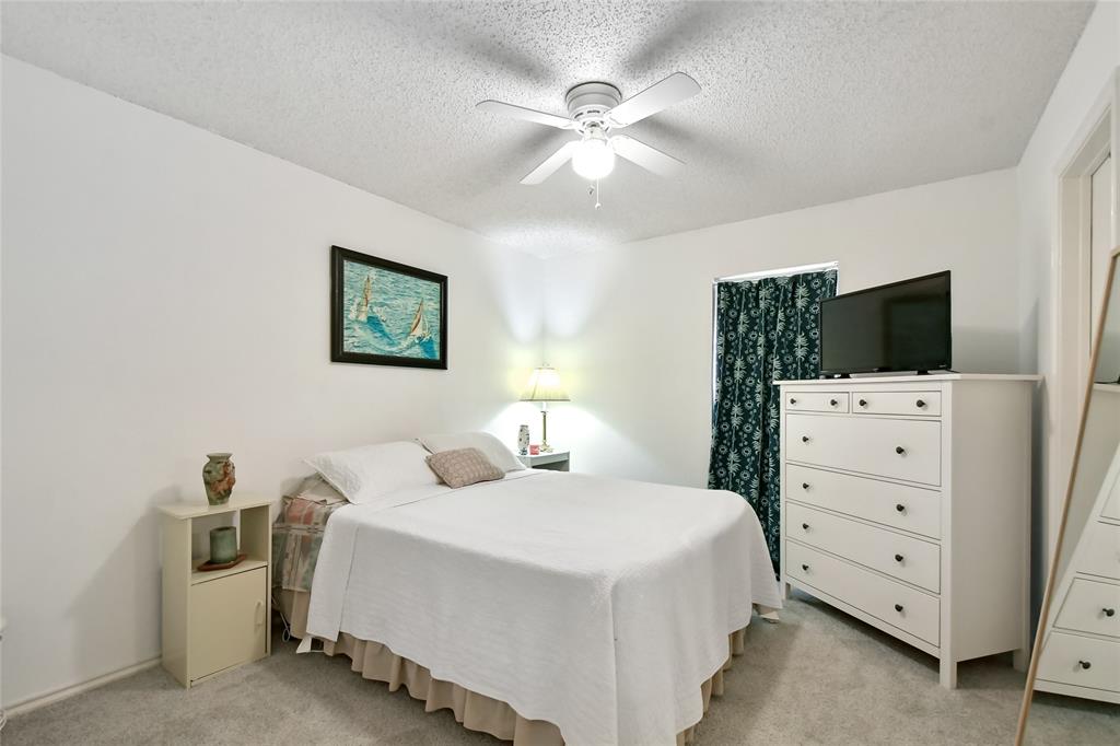 3129 Regency Carrollton, TX 75007 - Photo 20 of 29 a bedroom with a bed and a flat tv screen on dresser