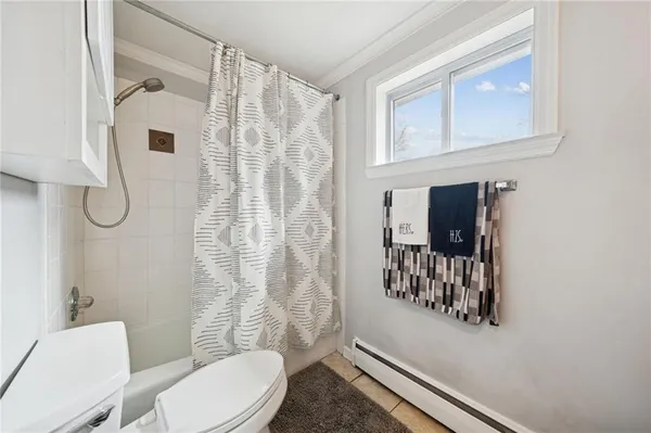 a bathroom with a toilet and shower curtain