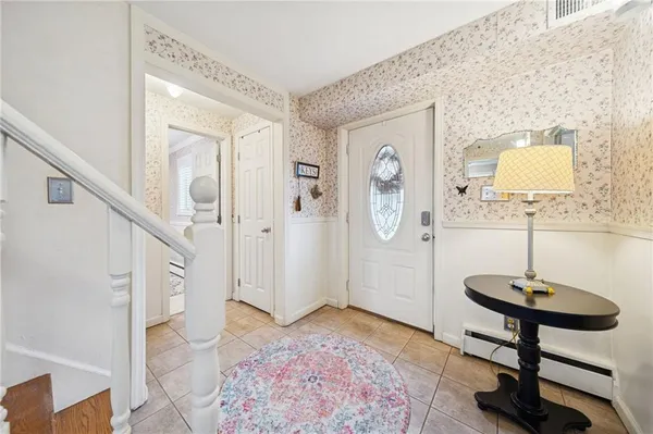 a view of a hallway with wooden floor and a chandelier