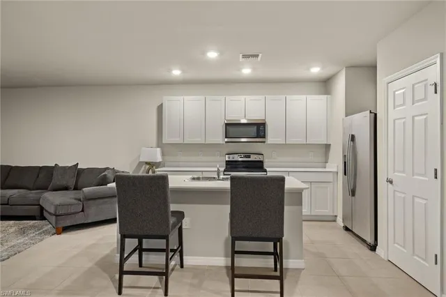 a kitchen with stainless steel appliances kitchen island granite countertop a refrigerator and a stove top oven