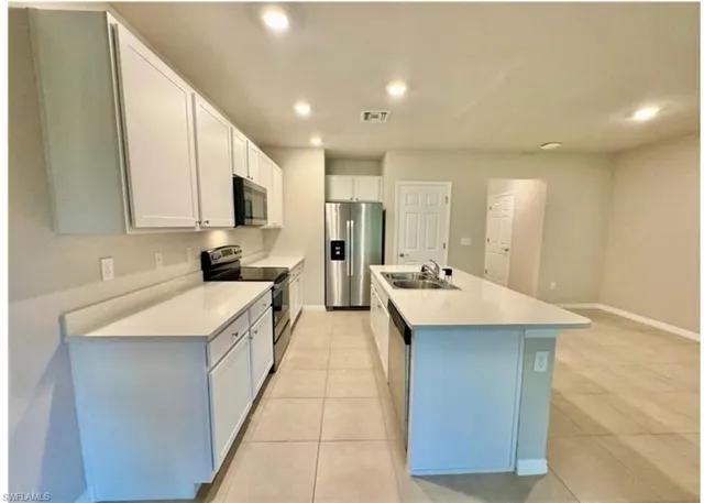 a kitchen with kitchen island a sink stove and refrigerator