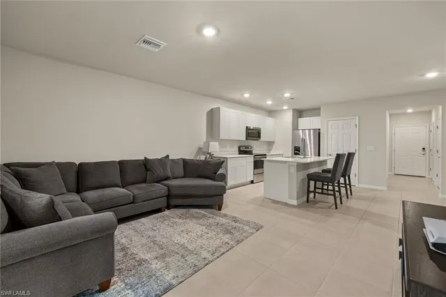 a living room with furniture and kitchen view