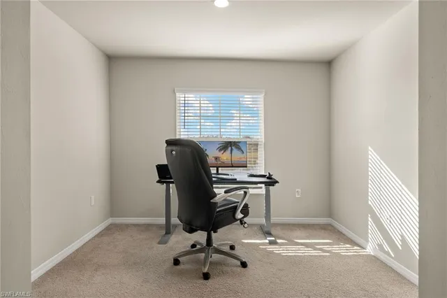 a view of a workspace with furniture and a window