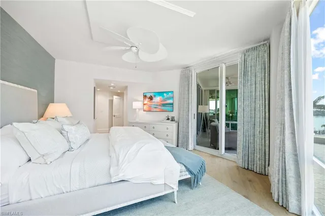 a bedroom with a large bed and a chandelier