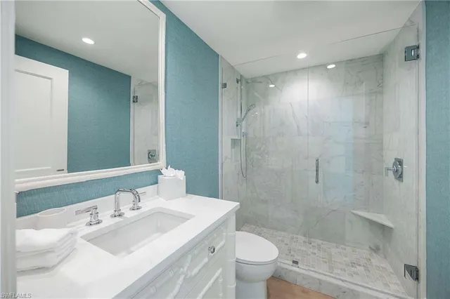 a bathroom with a sink a toilet and shower