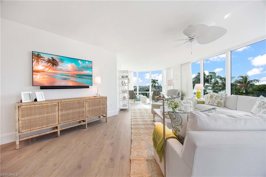 3971 Gulf Shore Boulevard North, Unit 401 Naples, FL 34103 - Photo 10 of 50 a living room with furniture and a flat screen tv