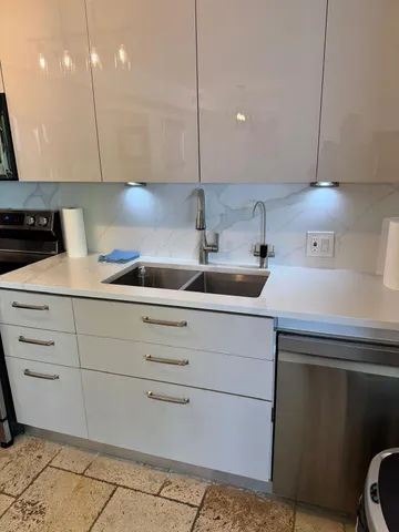 a kitchen with stainless steel appliances a sink stove top oven and cabinets