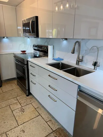 a kitchen with stainless steel appliances granite countertop a refrigerator and a stove top oven