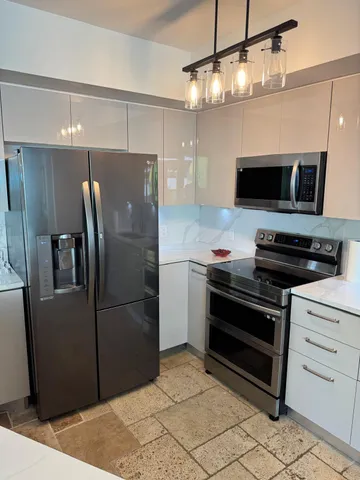 a view of kitchen with refrigerator and window