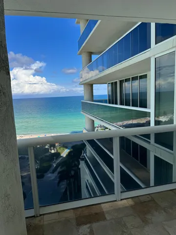 a living room with stainless steel appliances kitchen island granite countertop a stove and a sink