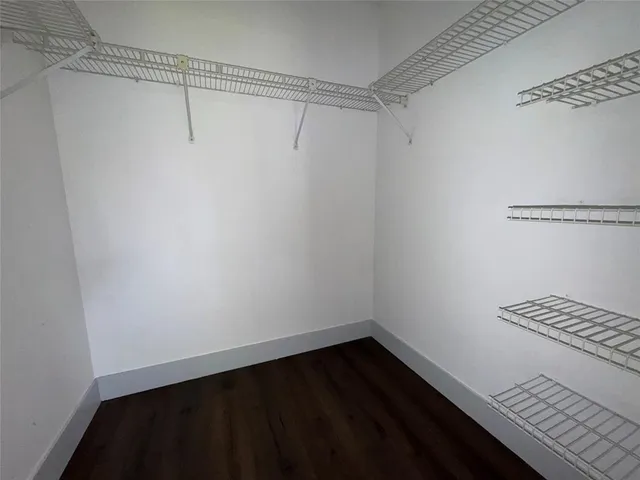 a view of a room with wooden floor and white walls