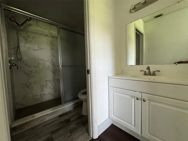 a bathroom with a shower sink and mirror