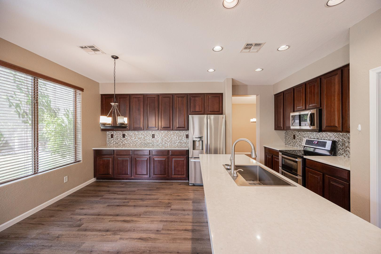 6539 West Jomax Road Phoenix, AZ 85083 - Photo 7 of 39 a large kitchen with kitchen island a sink a counter top space stainless steel appliances and cabinets