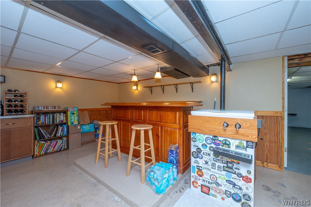 6463 Ward Road Sanborn, NY 14132 - Photo 32 of 49 An inviting lower level recreation area features a built-in wooden bar and paneled accents.
