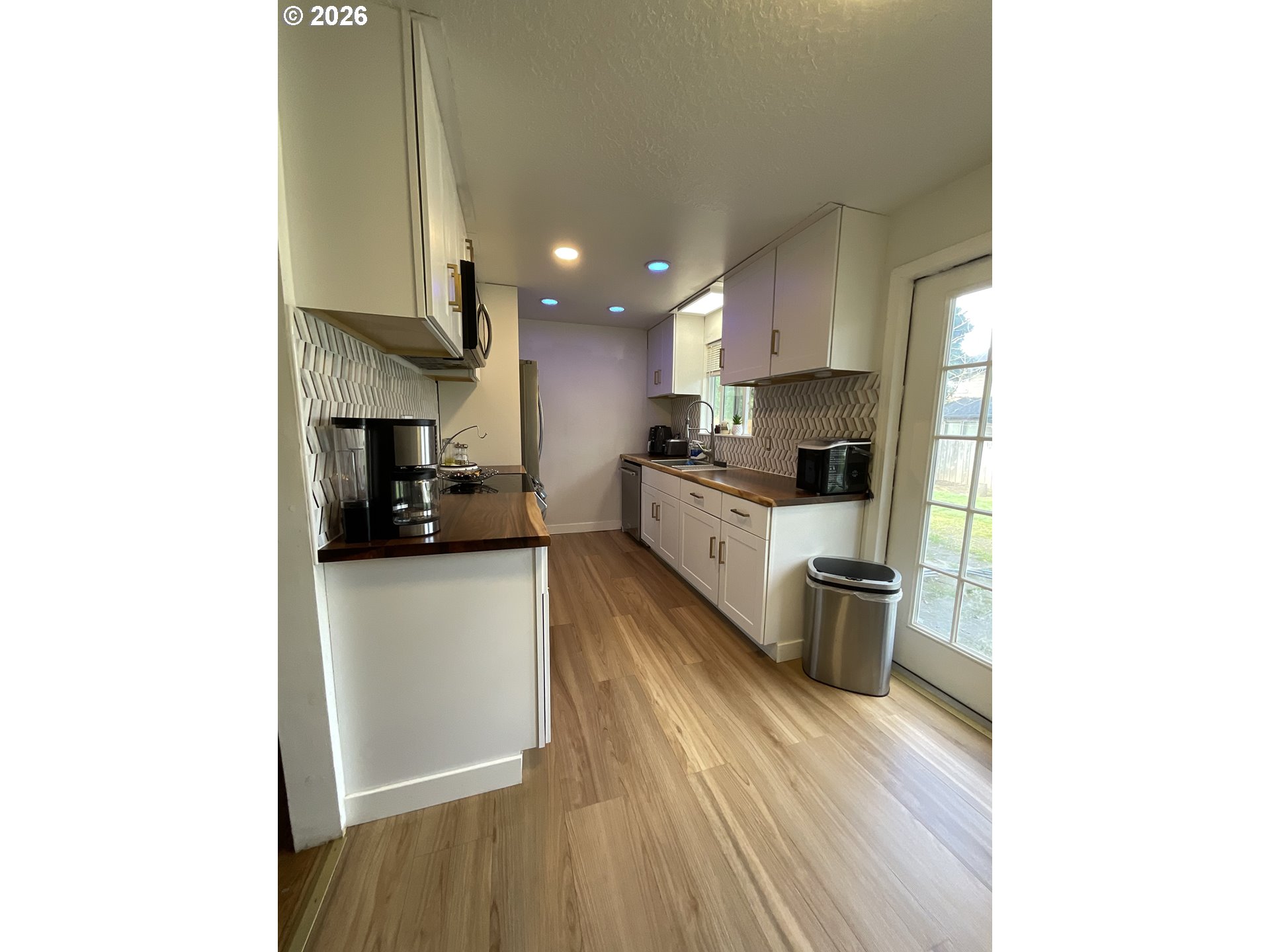 19305 Southwest York Street Beaverton, OR 97003 - Photo 12 of 34 a kitchen with stainless steel appliances a sink a stove top oven a refrigerator and cabinets