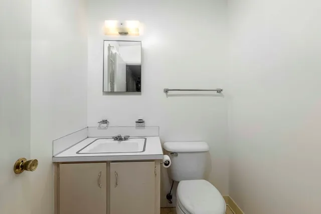 a bathroom with a sink mirror and toilet
