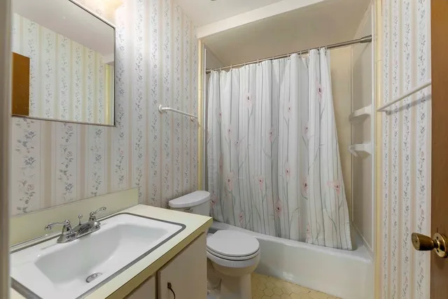 a bathroom with a sink a toilet and mirror