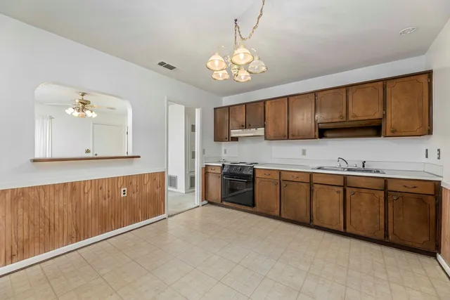 a large kitchen with cabinets a sink and dishwasher