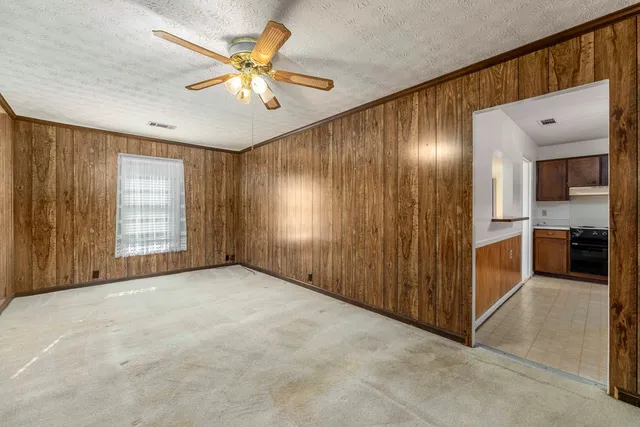 a view of an empty room with a ceiling fan and a window
