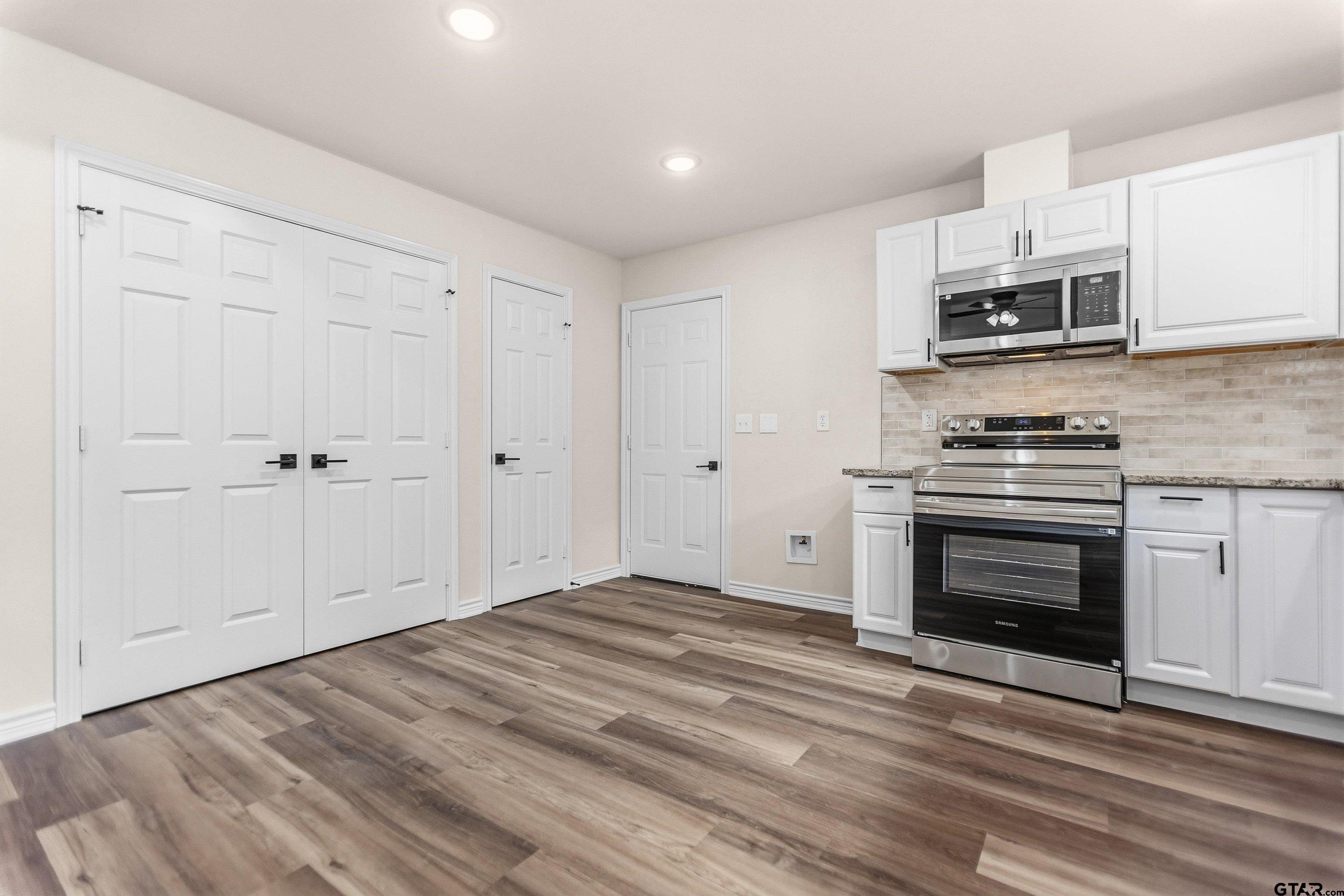 22463 Trailwood Road Flint, TX 75762 - Photo 4 of 17 a kitchen with stainless steel appliances granite countertop a stove and a microwave