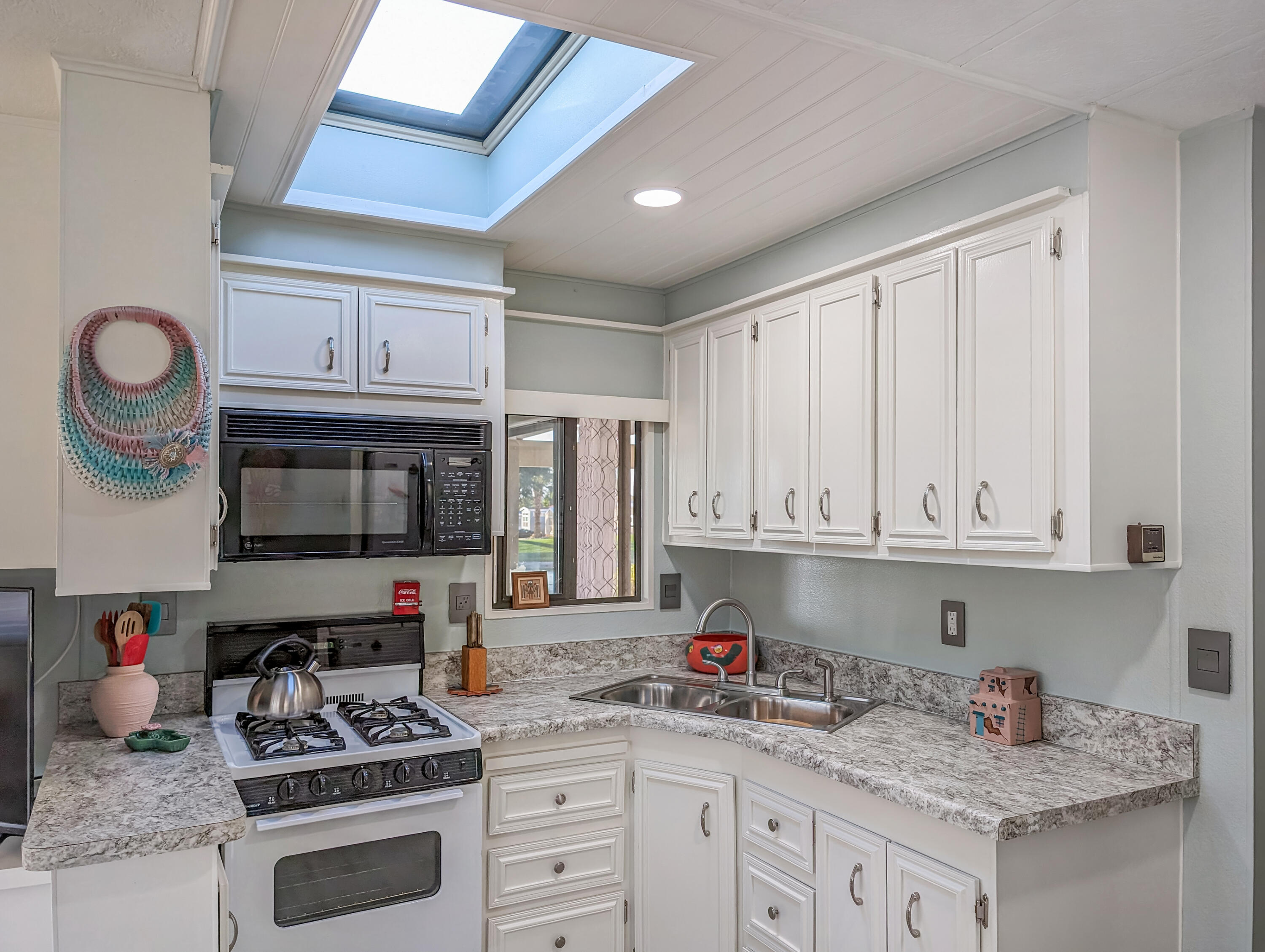70200 Dillon Road, Unit 111 Desert Hot Springs, CA 92241 - Photo 8 of 25 a kitchen with stainless steel appliances granite countertop a stove a sink and a microwave