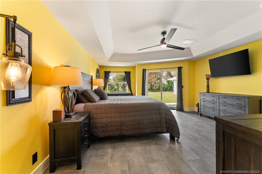 2072 Southeast Hanford Road Port St. Lucie, FL 34952 - Photo 23 of 58 a bedroom with a bed and flat screen tv