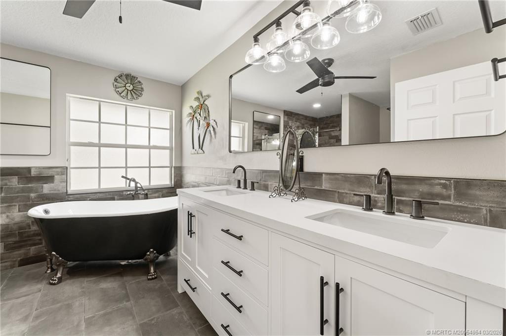 2072 Southeast Hanford Road Port St. Lucie, FL 34952 - Photo 26 of 58 a bathroom with a sink double vanity and a mirror
