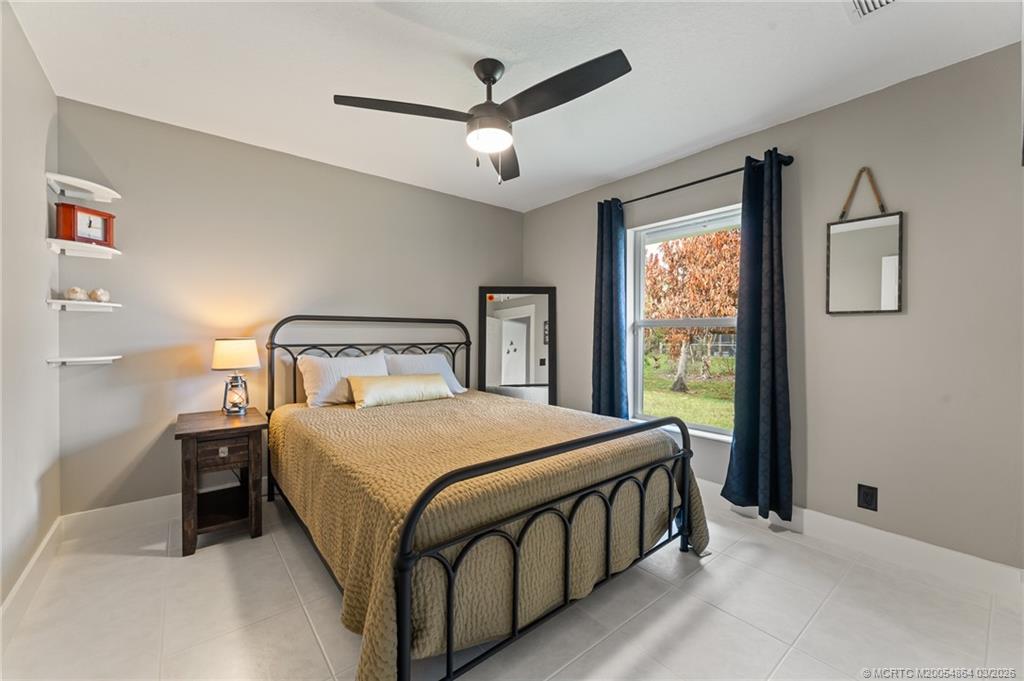 2072 Southeast Hanford Road Port St. Lucie, FL 34952 - Photo 41 of 58 a bedroom with a bed next to a window