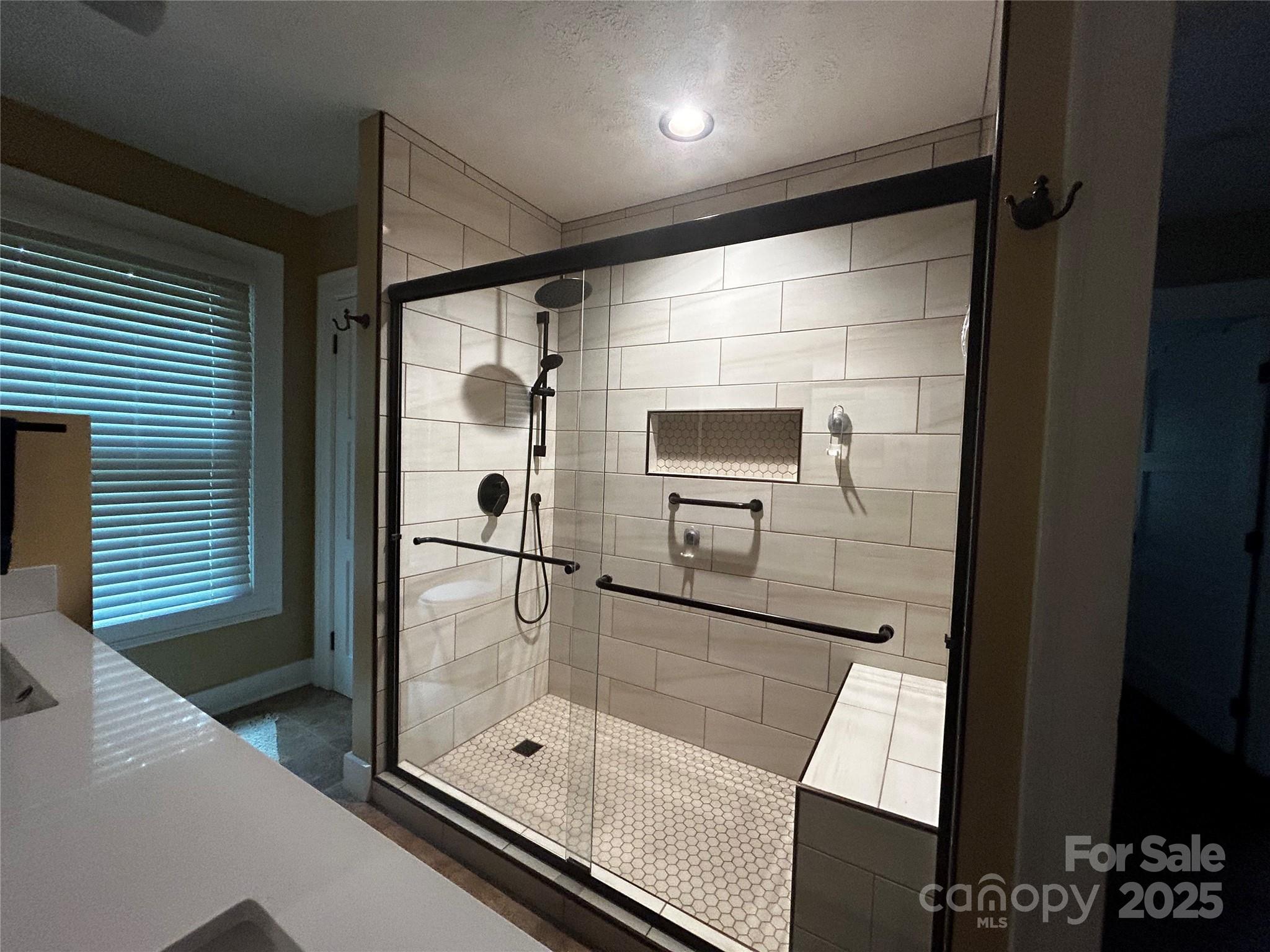 283 Bull Creek Road Asheville, NC 28805 - Photo 18 of 35 a bathroom with a glass shower door and a glass door