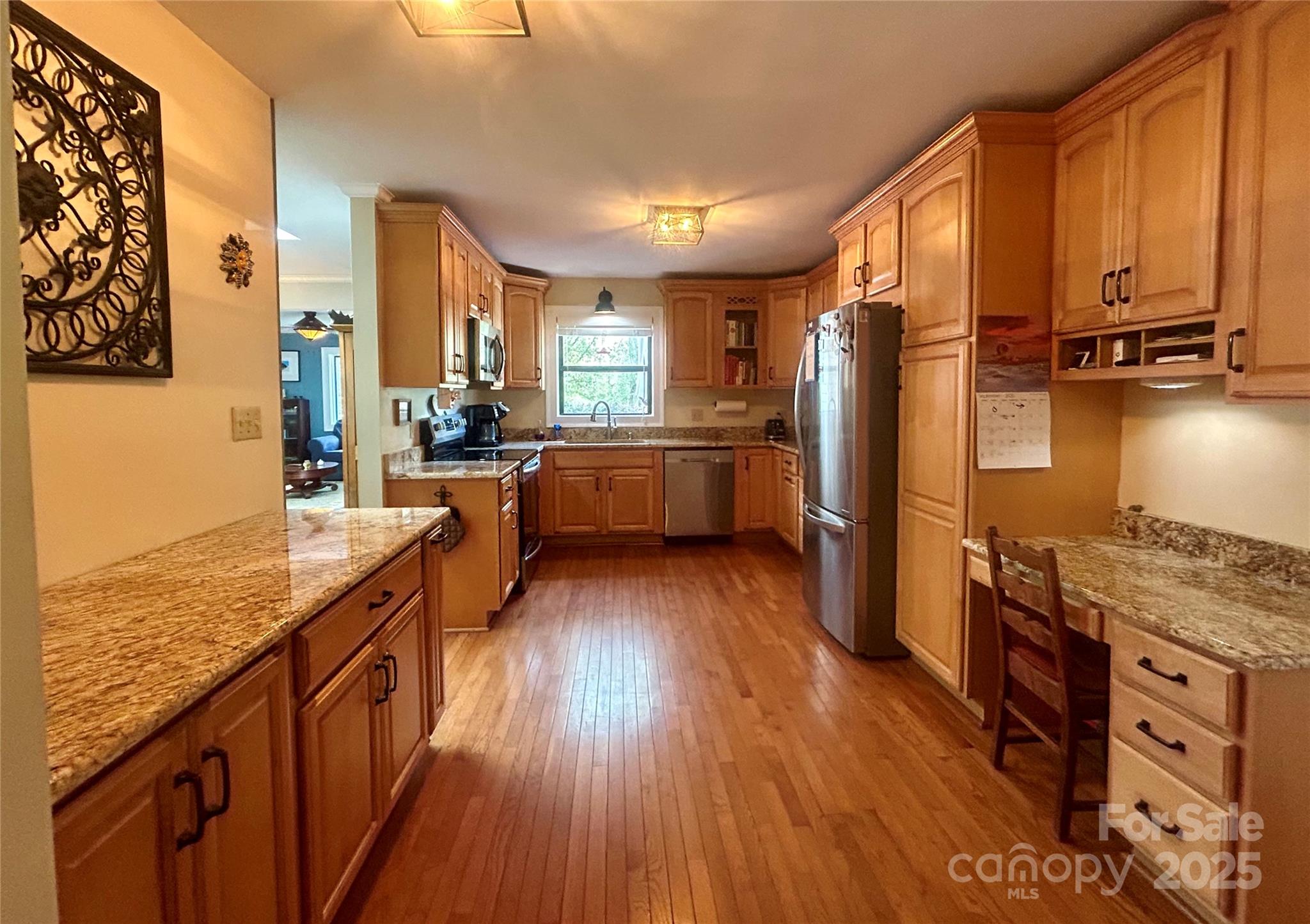 283 Bull Creek Road Asheville, NC 28805 - Photo 10 of 35 a kitchen with stainless steel appliances granite countertop hardwood floor sink stove and wooden cabinets