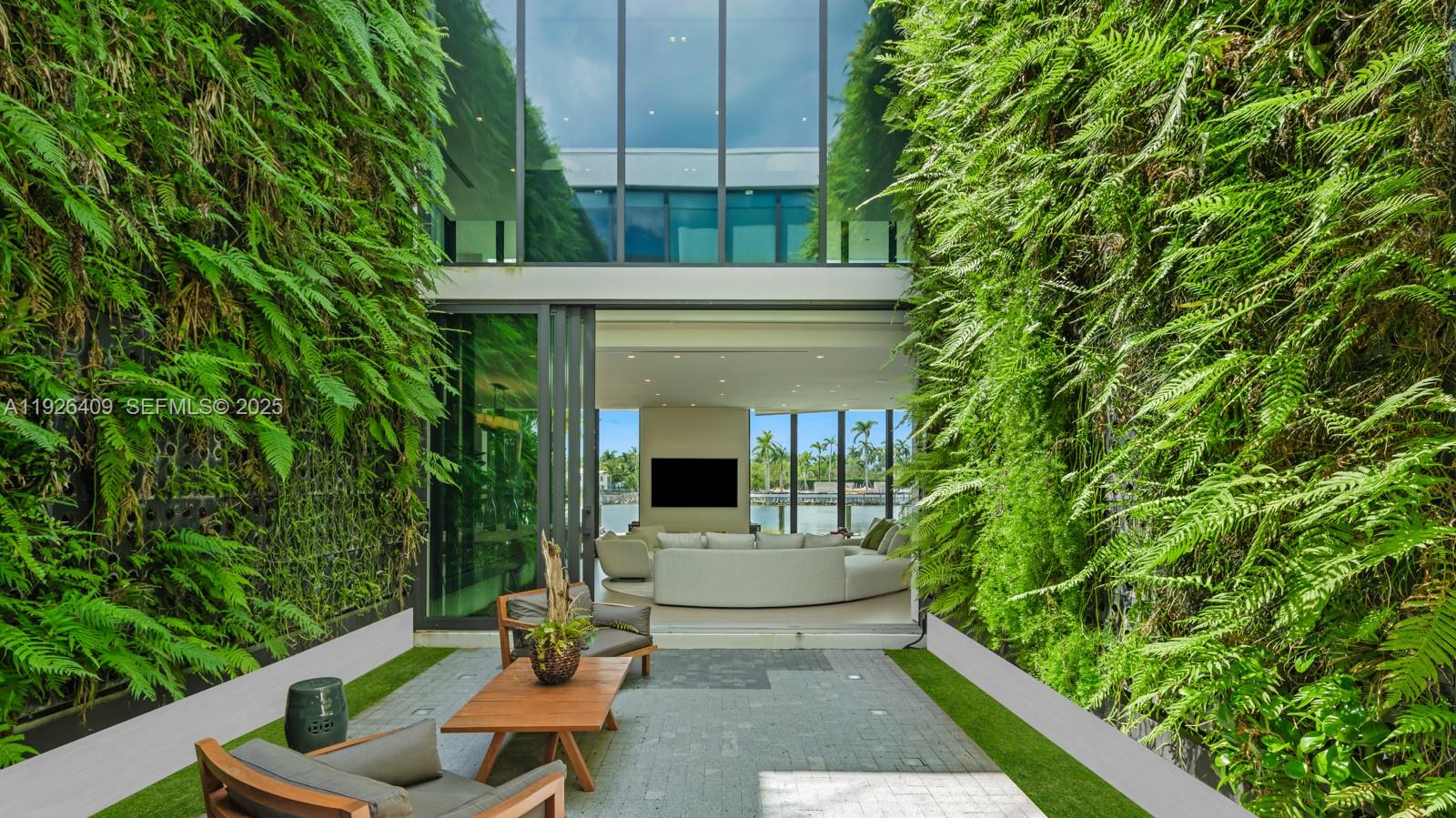 6480 Allison Road Miami Beach, FL 33141 - Photo 34 of 66 a view of a patio with table and chairs potted plants and floor to ceiling window