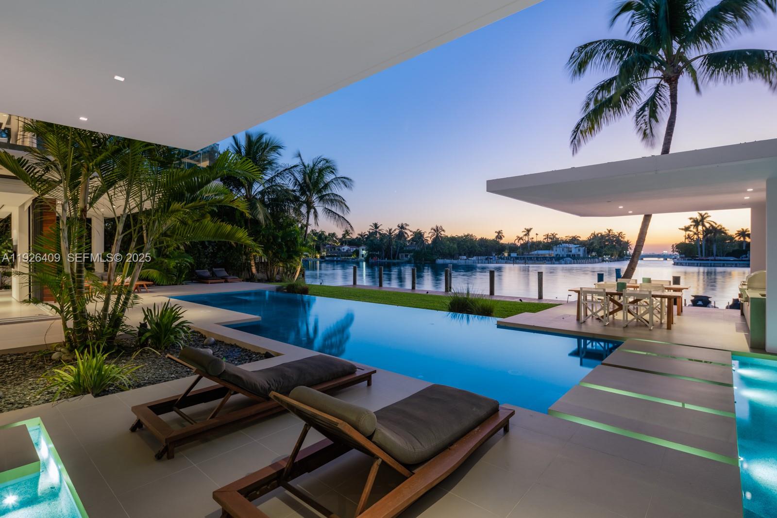 6480 Allison Road Miami Beach, FL 33141 - Photo 42 of 66 a view of a swimming pool with lounge chairs
