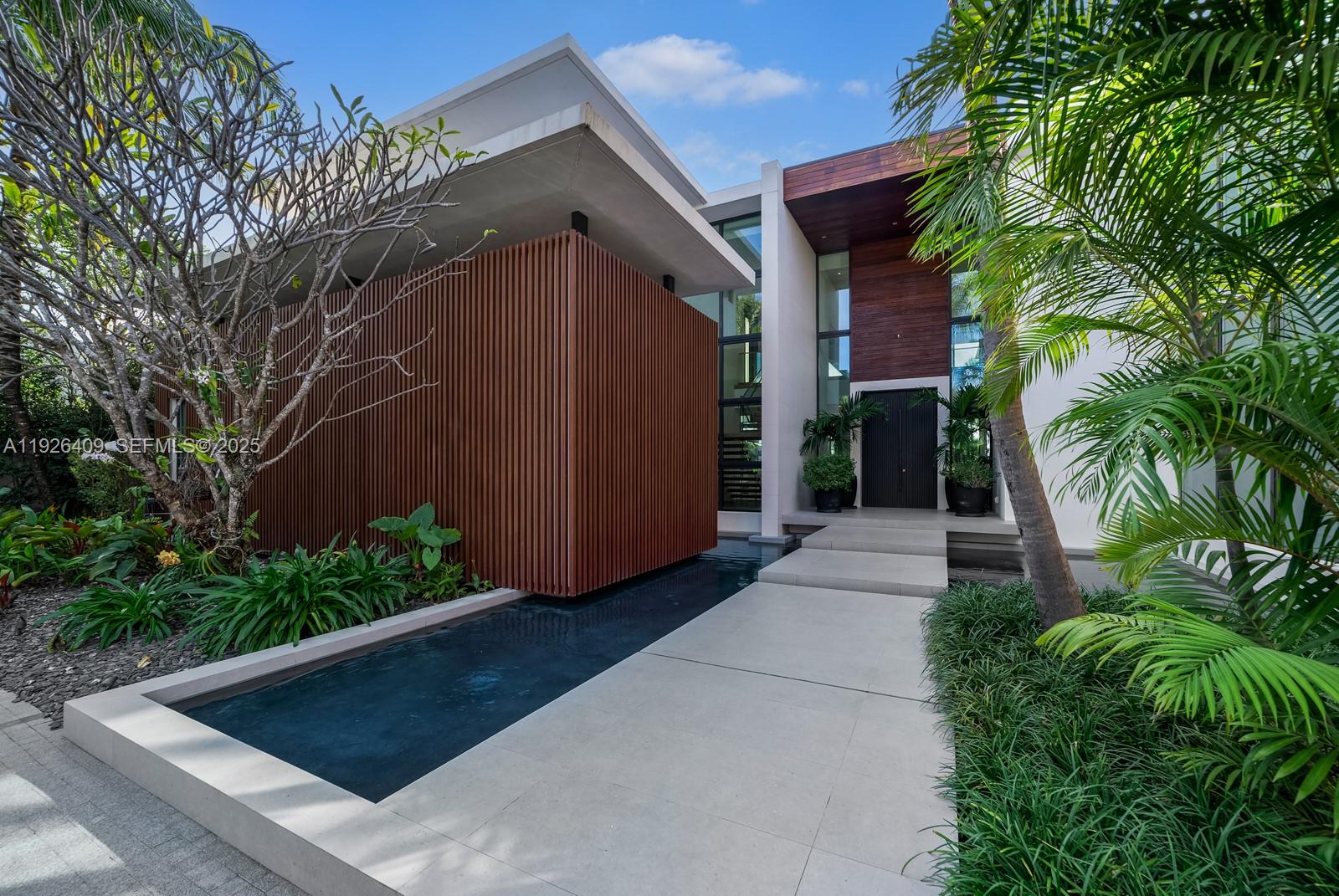 6480 Allison Road Miami Beach, FL 33141 - Photo 63 of 66 a view of backyard with potted plants and large tree