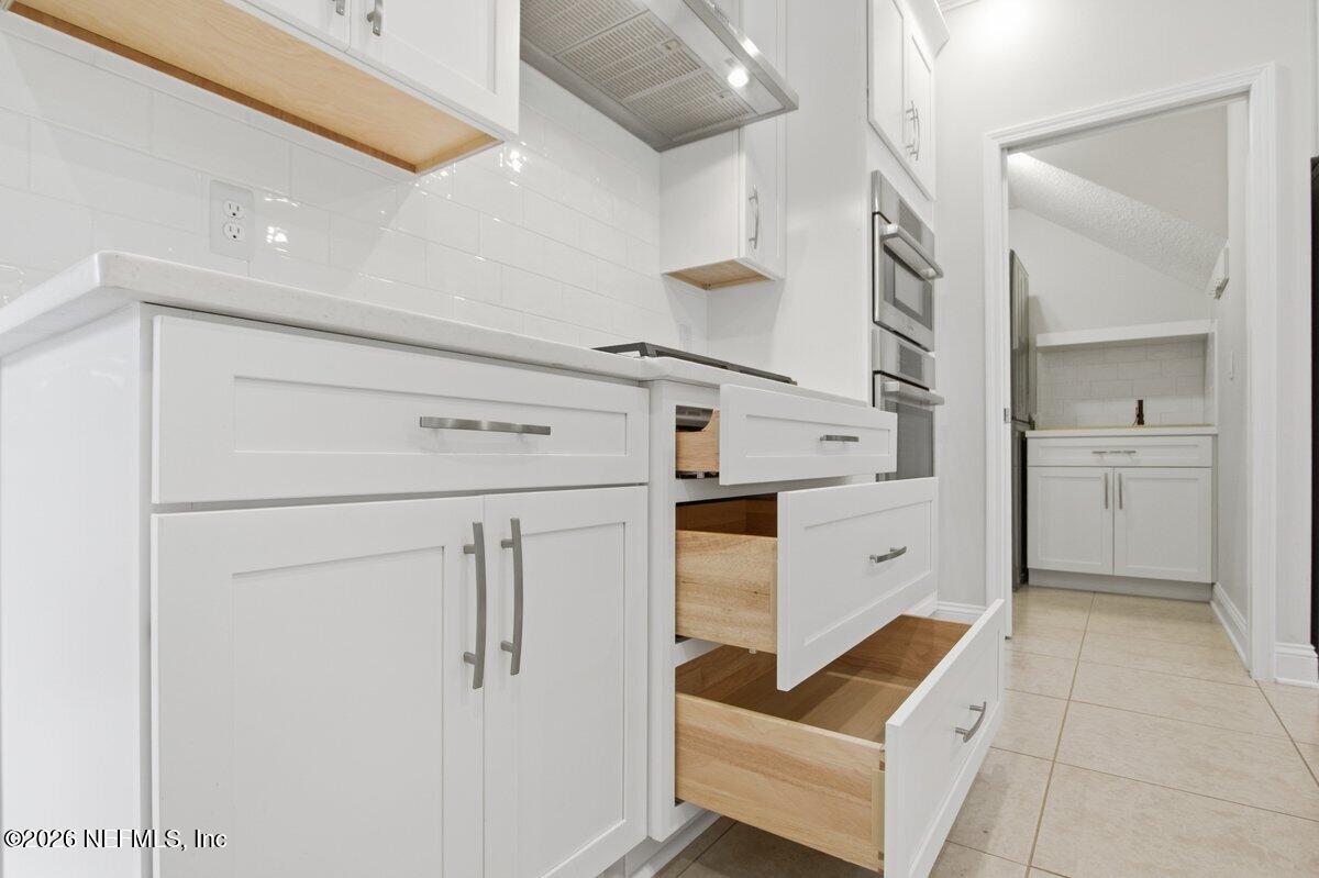 75 Myrtle Park Point Ponte Vedra, FL 32081 - Photo 7 of 38 a kitchen with white cabinets and white appliances
