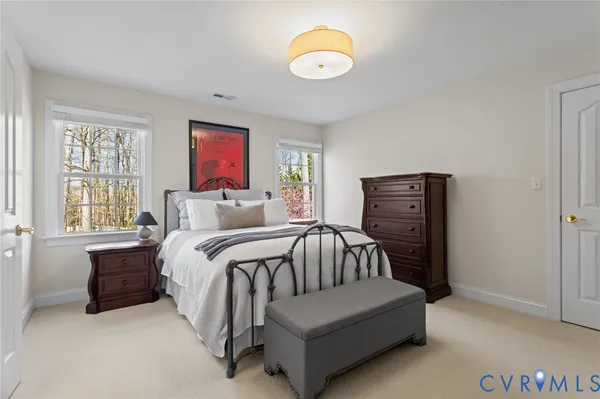 a spacious bedroom with a bed and a chandelier