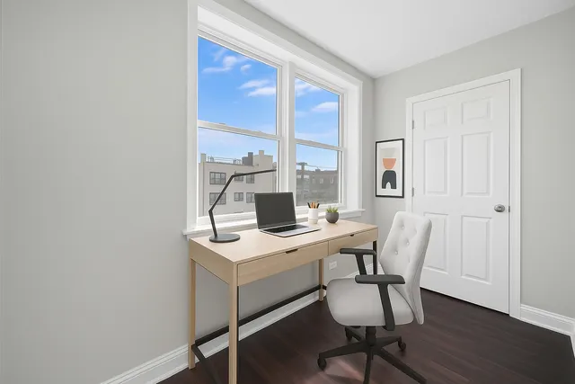 a view of a workspace with furniture and a window