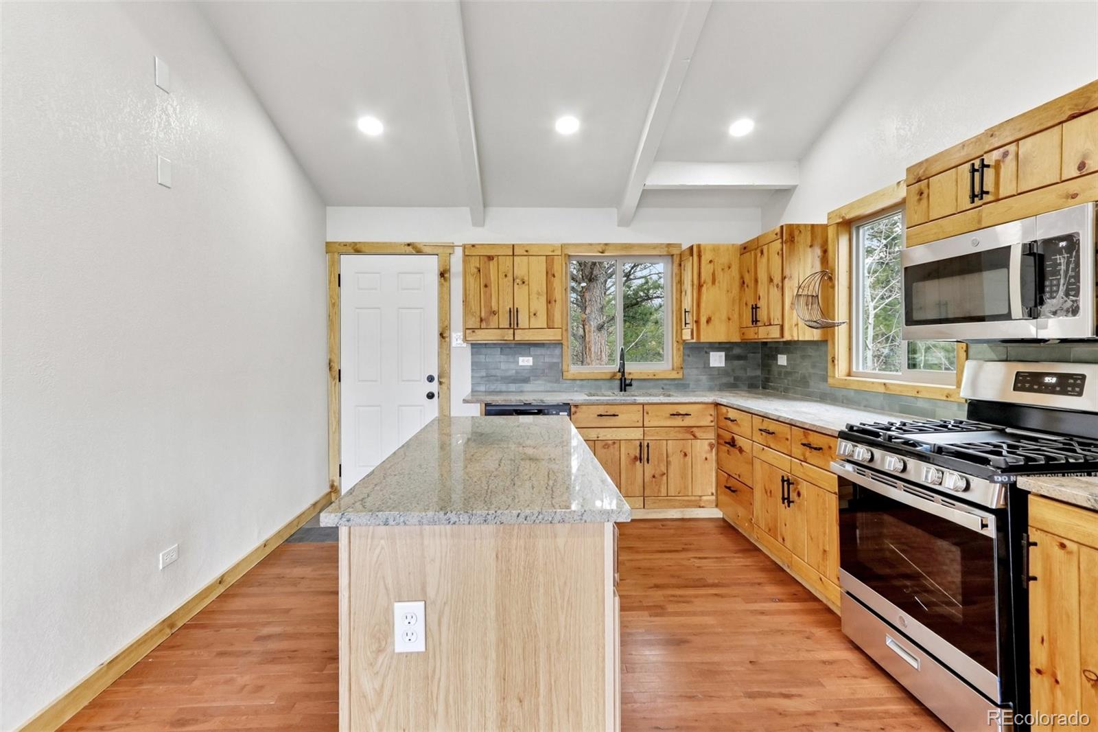 61 Evergreen Road Black Hawk, CO 80422 - Photo 12 of 50 a kitchen with stainless steel appliances granite countertop a sink a stove and a wooden floors