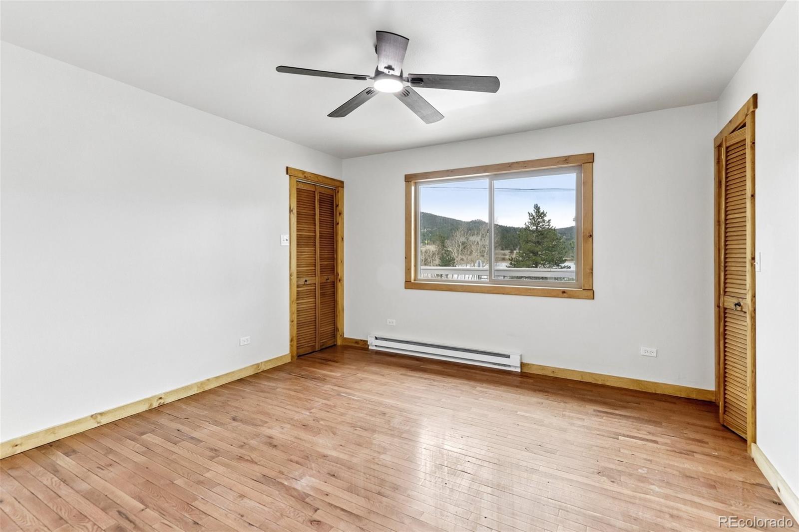 61 Evergreen Road Black Hawk, CO 80422 - Photo 28 of 50 an empty room with wooden floor chandelier fan and windows