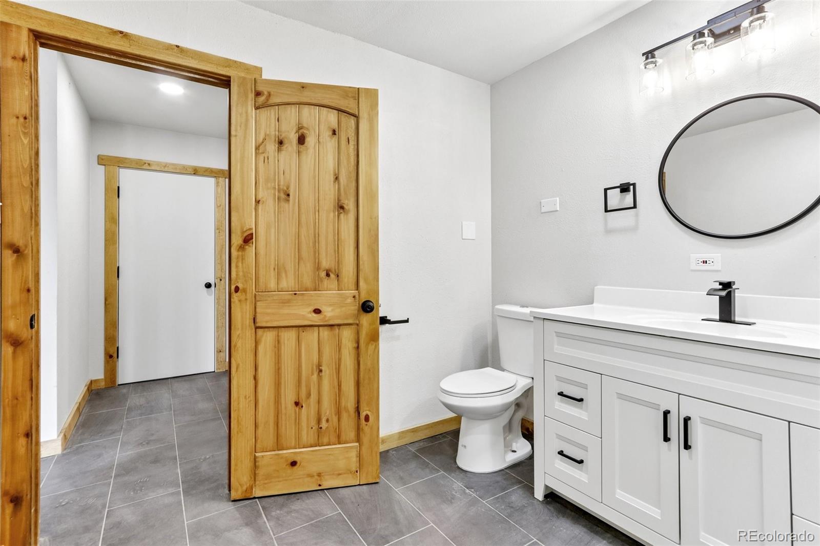 61 Evergreen Road Black Hawk, CO 80422 - Photo 29 of 50 a bathroom with a granite countertop sink toilet mirror and a mirror