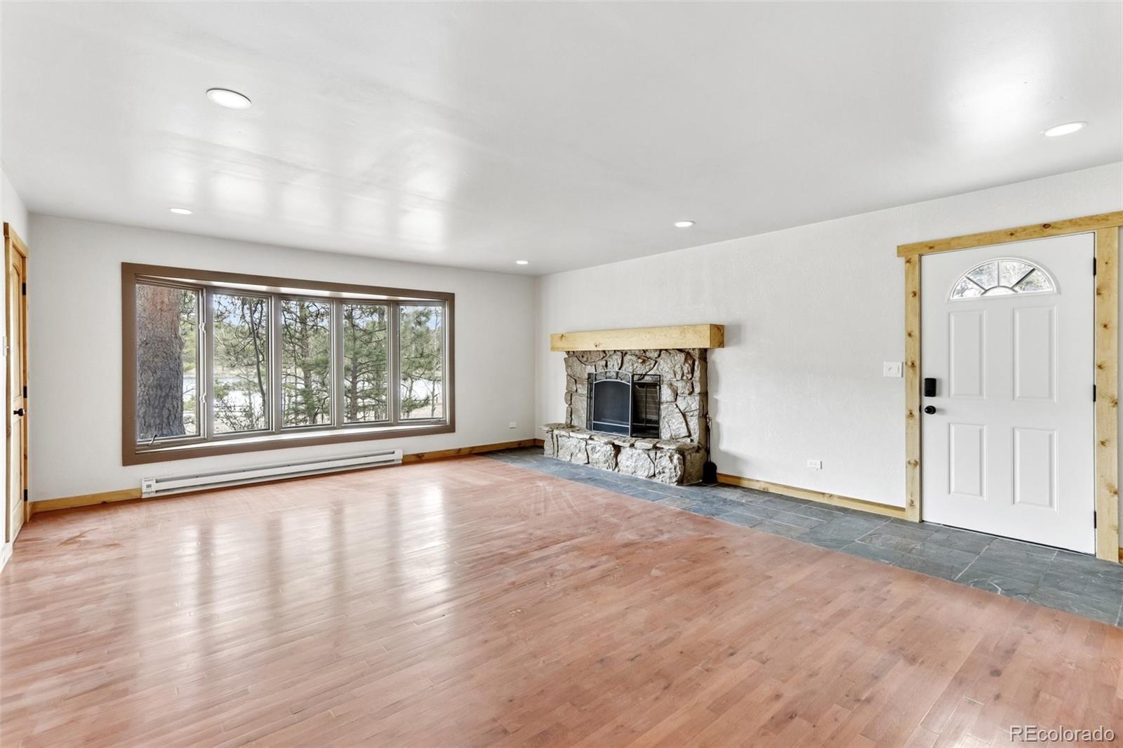 61 Evergreen Road Black Hawk, CO 80422 - Photo 34 of 50 a view of empty room with wooden floor and fireplace