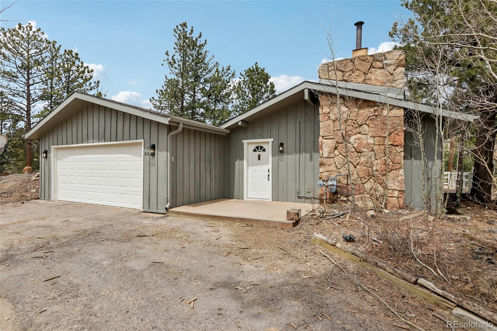 61 Evergreen Road Black Hawk, CO 80422 - Photo 6 of 50 a front view of a house with a yard and garage