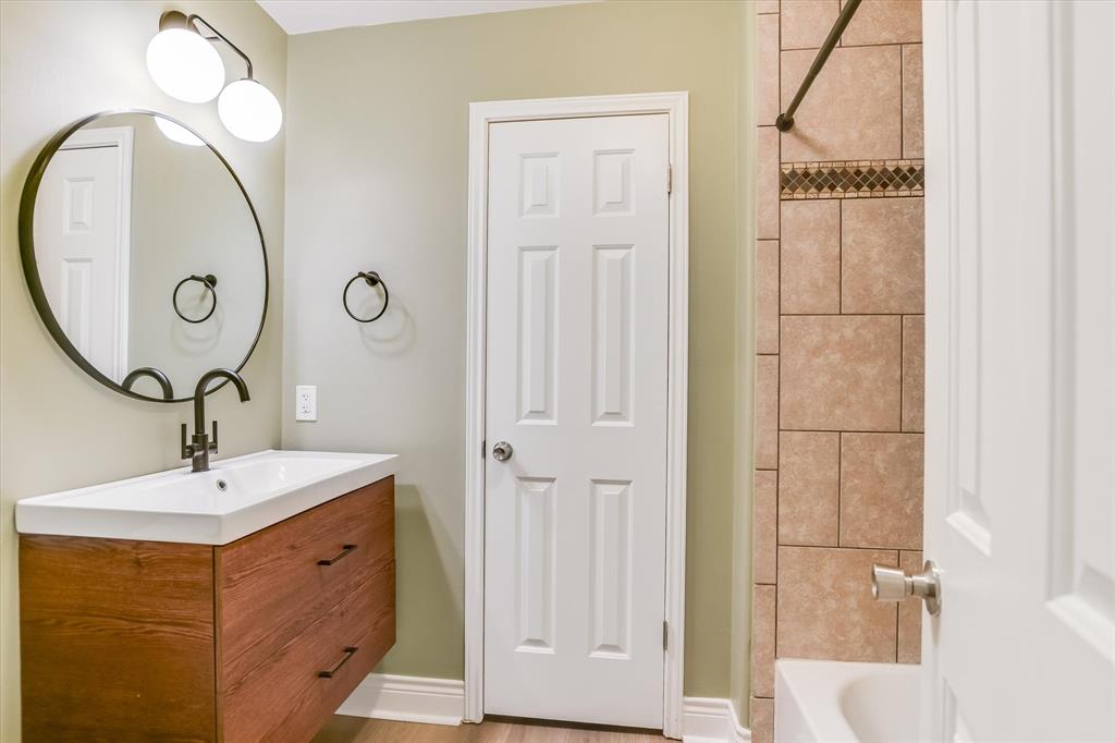 5405 Manor Road Austin, TX 78723 - Photo 11 of 30 Full bathroom featuring vanity, washtub / shower combination, and light wood finished floors