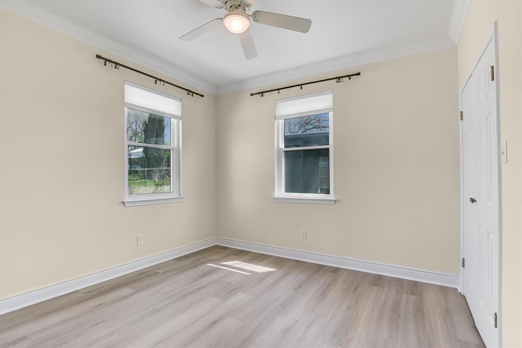 5405 Manor Road Austin, TX 78723 - Photo 12 of 30 Spare room featuring light wood finished floors, healthy amount of natural light, ornamental molding, and a ceiling fan