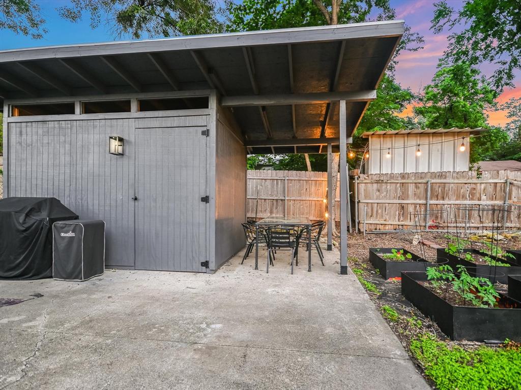 5405 Manor Road Austin, TX 78723 - Photo 18 of 30 View of patio / terrace with a vegetable garden, outdoor dining area, area for grilling, and a storage unit