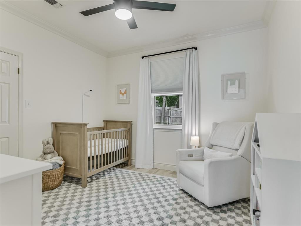 5405 Manor Road Austin, TX 78723 - Photo 22 of 30 Bedroom with a nursery area, ornamental molding, ceiling fan, and light wood-style floors